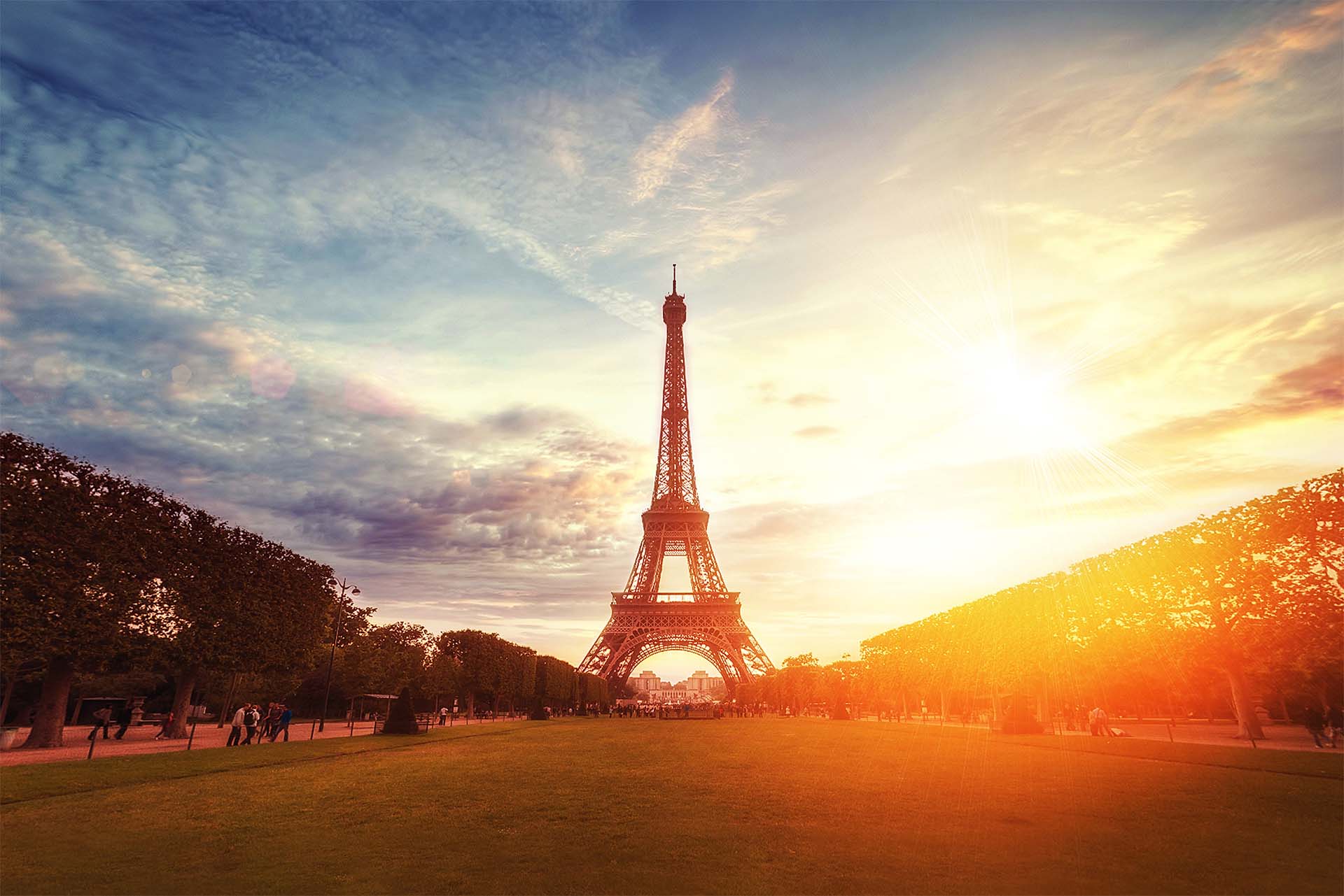 Beautiful wide shot of the famous Eifel tower under the breathtaking cloudy sky at sunrise in Paris